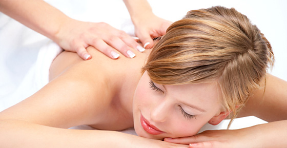 Frau mit geschlossenen Augen genießt eine Rückenmassage